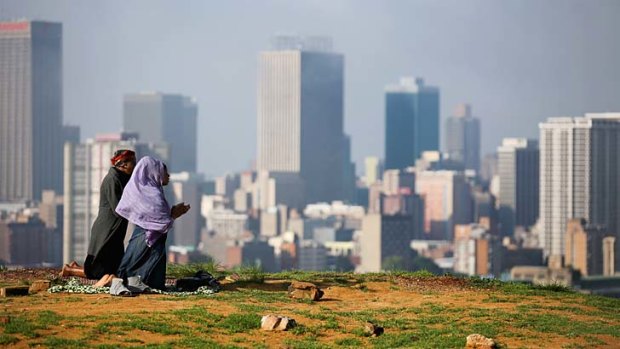 Follow the rainbow: Worshippers in prayer on a hill overlooking Johannesburg in 2013 following news of Mandela's death.