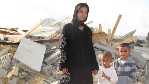 Demolished ... Rifa al-Oqbi and her sons Omar, 4, and Ali, 5, stand amid the ruins of their home, demolished by Israeli authorities, in the village of al-Qrain.
