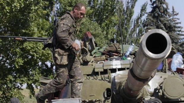 A Ukrainian serviceman loads a shell onto a tank at a checkpoint in the southern coastal town of Mariupol.