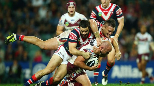 Double safety: Glenn Stewart of the Eagles is tackled by Aidan Guerra and Jared Waerea-Hargreaves of the Roosters.