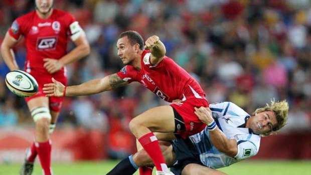 Resurgence ... Queensland Reds star Quade Cooper tries to escape a tackle by the Bulls' Wynand Olivier.