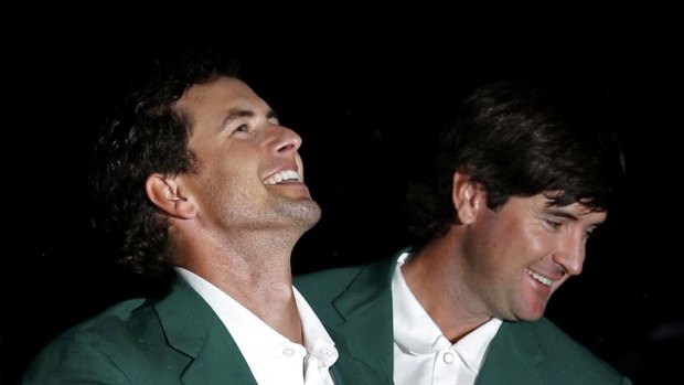 Adam Scott receives his green jacket from 2012 champion Bubba Watson of the U.S.
