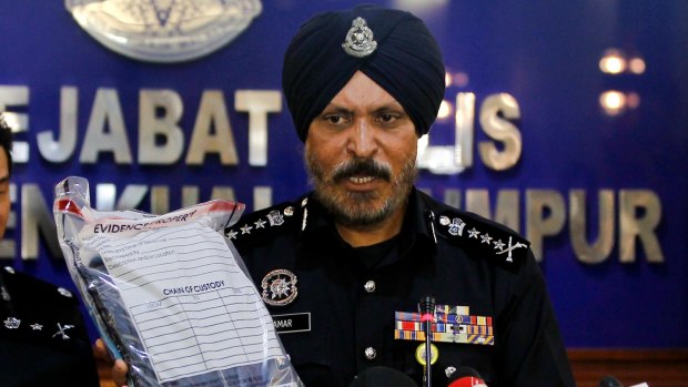 Kuala Lumpur police chief Amar Singh holds up the belongings of a detained suspect.