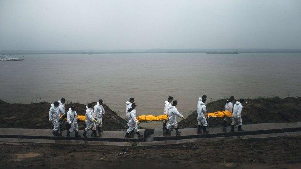 Rescuers carry the bodies of the victims of the capsized Chinese cruise ship in Jianli, on Wednesday. 