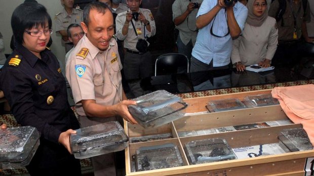 Indonesian customs officials display crates of  the pig-nosed turtles  after they were  returned from Hong Kong.