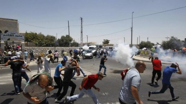 Palestinian protesters run away from tear gas fired by Israeli soldiers during clashes in the Arab east Jerusalem neighbourhood of Ras al-Amud.