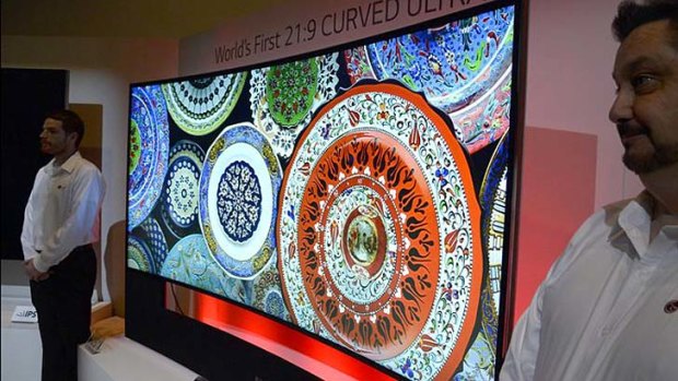 The world's first curved television - the LG Curved Ultra 108-inch HD TV - guarded by LG employees after being unveiled at CES 2014.