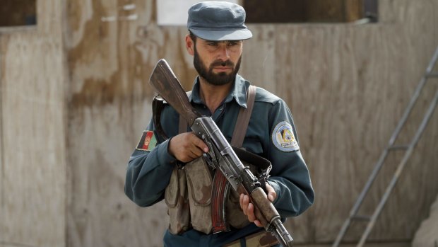 An Afghan policeman stands guard at his checkpoint in Kandahar earlier this month.