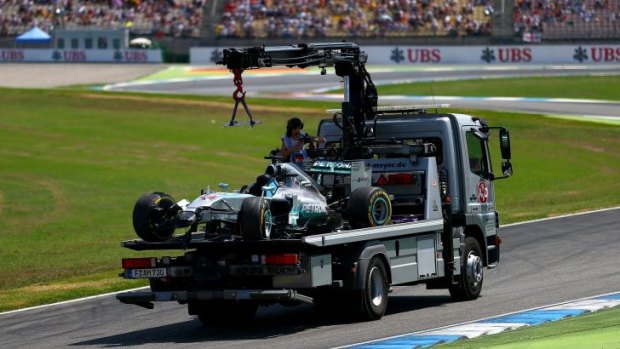Back to the pits: Lewis Hamilton's Mercedes is transported back to the garage in Hockenheim.