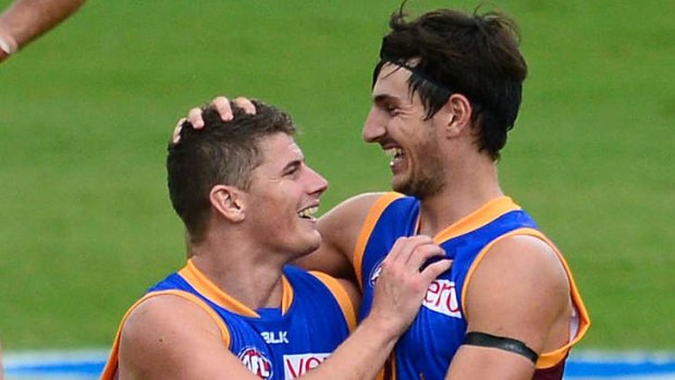 Dayne Zorko of the Lions is congratulated by teammate Sam Mayes.