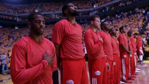 Los Angeles Clippers players listen to the national anthem wearing their warm-up jerseys inside out to protest alleged racial remarks by team owner Donald Sterling.