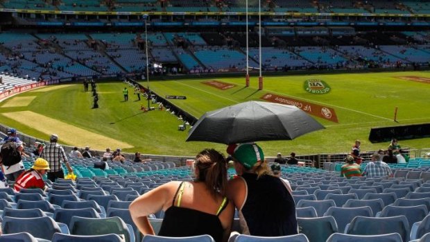 NRL fans protect themselves against the heat before the 2014 NRL grand final at ANZ Stadium.