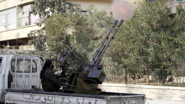 A member of Islamist Syrian rebel group Jabhat al-Nusra fires a weapon on the back of a truck in Aleppo.