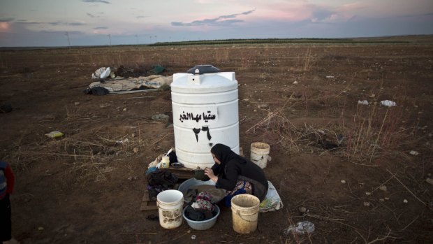 A Syrian woman washes her laundry near the Syrian border on the outskirts of Mafraq, Jordan.