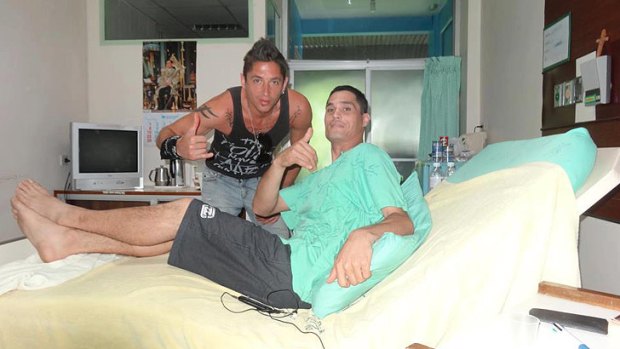 Sean with a visitor in hospital in Thailand.
