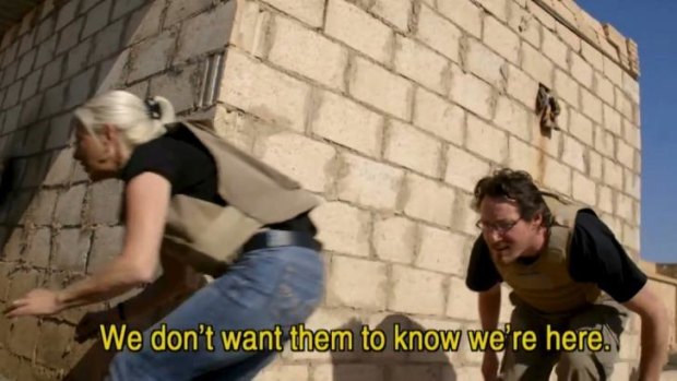 Terror ... Kim Vuga and Andrew Jackson scramble for cover after mortar rounds hit the abandoned school in which they are filming.