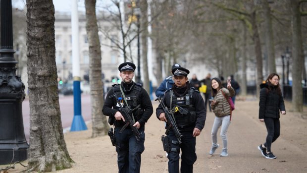 Armed police officers patrol The Mall in front of Buckingham Palace ahead of the Changing of the Guard ceremony. 