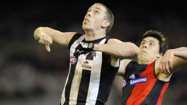 Collingwood's Nick Maxwell and Essendon's Angus Monfries fly for the ball last night.