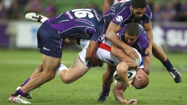 Tragic: Alex McKinnon falls awkwardly in three-man Storm tackle.