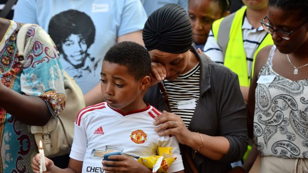 Emotions run high as people attend a candle lit vigil outside Notting Hill Methodist Church near Grenfell Tower.