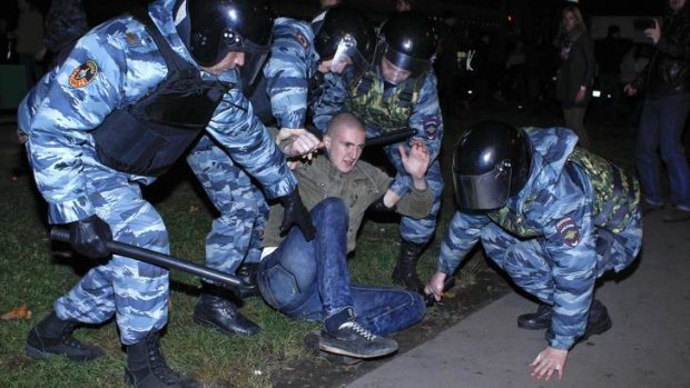 Prelude to migrant round-up: Russian police grapple with a man during a riot at a Moscow market on Sunday night. The following day police raided the market and detained about 1200 people.