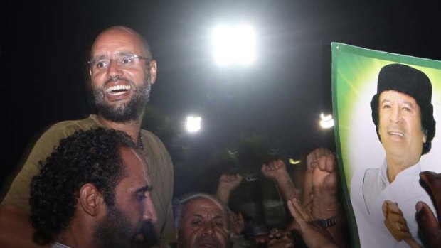 At liberty ... Gaddafi's son Saif al-Islam, top left, told supporters yesterday that all was well in Tripoli. The previous day rebels claimed to have captured him.