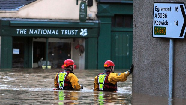 Emergency rescue workers wade through a flooded street in Cockermouth, in north-west England.