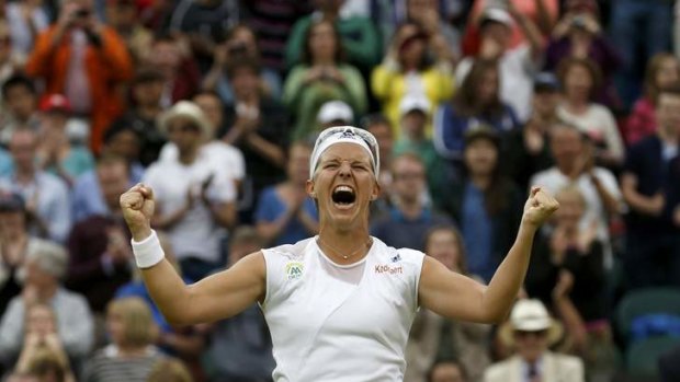 Kirsten Flipkens of Belgium celebrates after defeating Petra Kvitova of the Czech Republic in their women's quarter-final tennis match at Wimbledon.