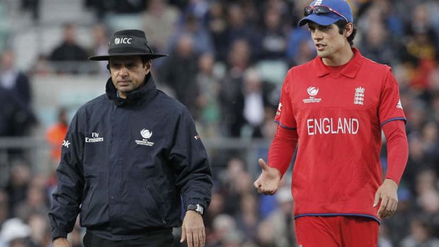 England's captain Alastair Cook talks with umpire Aleem Dar.