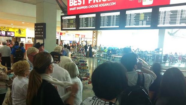 Waiting game: Travellers scan the arrival and departure boards at Melbourne Airport.