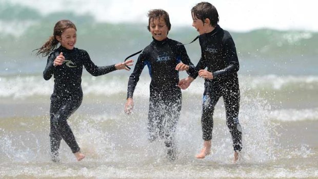 Poppy Gee, Hugh and Flynn Hanrahan have fun on the beach at Wye River on Tuesday.