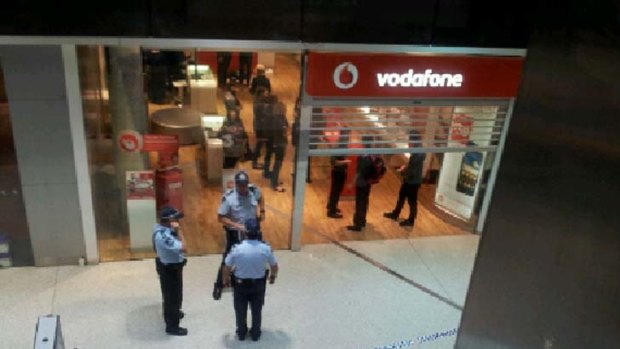 Police gather at the site of a shooting in Robina Town Centre.
