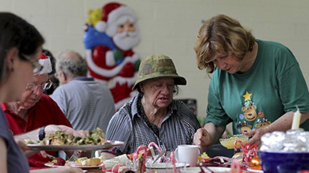 Rita Curtis, right, helps Mary Johnston with lunch at the 50 Lives 50 Homes Christmas feast at Kurilpa Hall, West End.