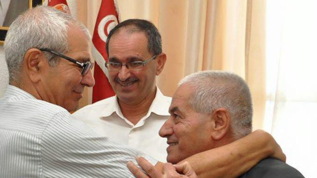 Houcine Abassi, the head of Tunisian General Labour Union, right, is congratulated in his office.