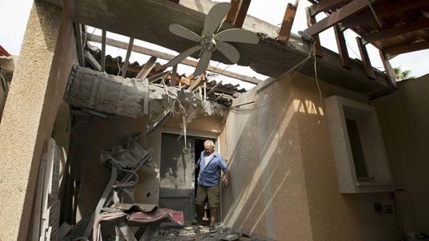 An Israeli man inspects the damage to his house following a rocket attack on the Israeli Kibbutz Ein Shlosha from the neighbouring Gaza Strip, on October 24, 2012.
