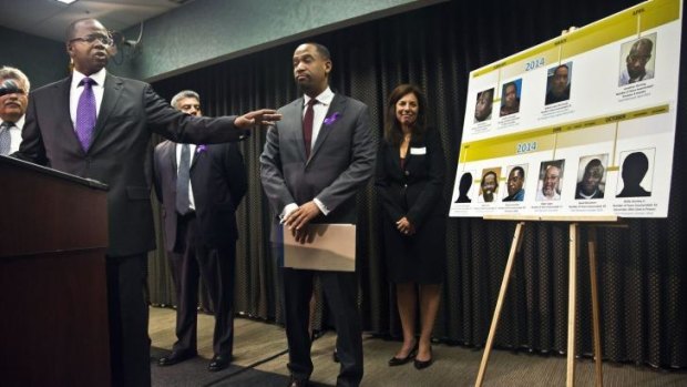 Nine and counting: Brooklyn District Attorney Ken Thompson, left, points to a time-line photo display of individuals exonerated in wrongful conviction cases, as he speaks during a press conference.