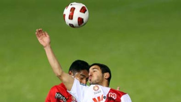Adelaide United's Cassio and Heart's Aziz Behich bang heads last night.