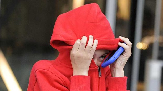 A 12 year-old boy shields his face as he leaves Manchester magistrates' court after admitting burglary, during the he recent riots in Manchester.