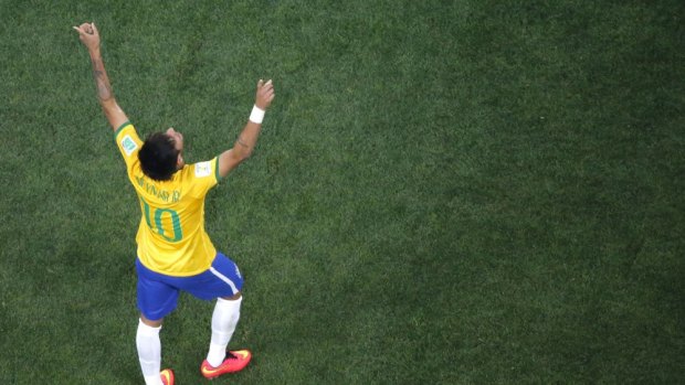 Brazil's forward Neymar celebrates after scoring against Croatia. Futbol is described as a religion by Brazilians who hope to win the World Cup at home despite unhappiness at government spending.