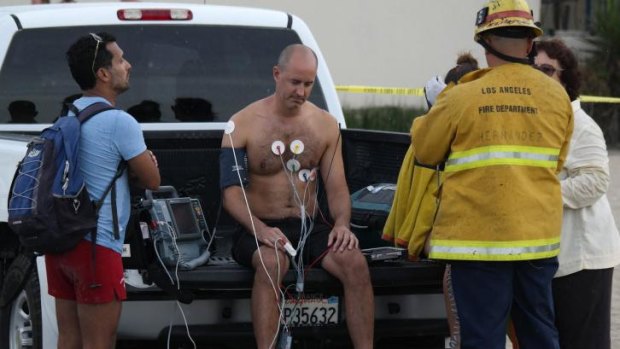 A man is treated by a paramedics after a lightning strike in the water in Venice, California.
