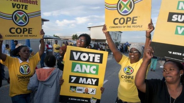 Supporters of the ruling African National Congress (ANC) and opposing Congress of the People (COPE) sing and dance together next to a polling station.
