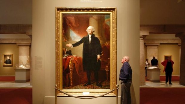 A man looks up at a painting of the first US President George Washington at the Smithsonian American Art Museum in Washington