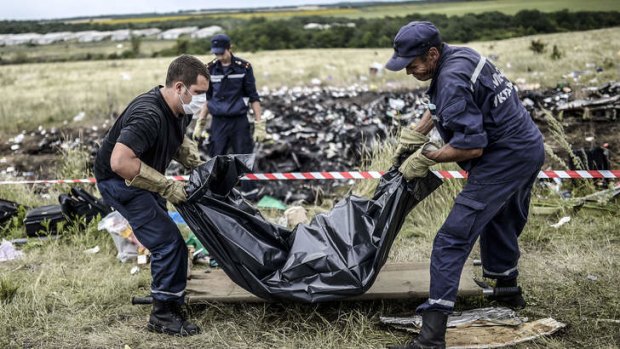 Ukrainian emergency workers collect the body of a victim at the MH17 crash site near Grabove, in rebel-held east Ukraine.