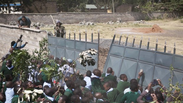 Kenyan children push down the wall leading to a playground during a protest in January. 