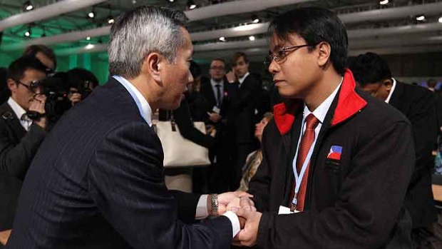 Japan's Hiroshi Minami (L) with Naderev Sano from the Philippines at the Warsaw climate summit.