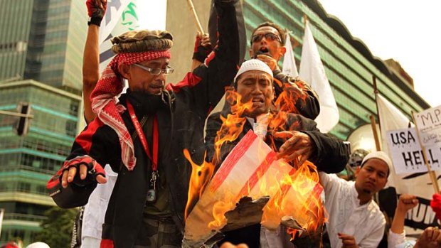 Police unprepared &#8230; Islamic Defenders Front members burn a poster of an American flag as hundreds of protesters clash with police at anti-US protests in Jakarta.