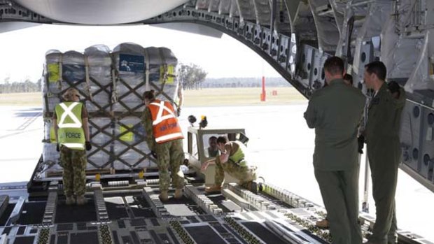 Air force staff load aid onto a plane bound for Pakistan. But using the military to deliver aid can be dangerous.