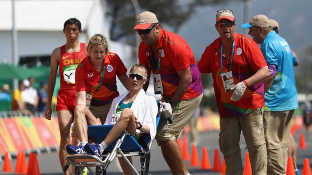 Giving all that you can give: Jared Tallent is wheeled away after crossing the finish line.