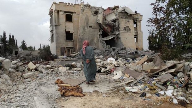 A Syrian man inspects the damage following a US-led coalition air strike.
