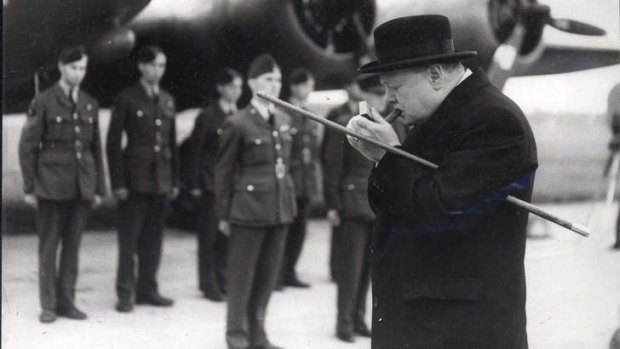 Winston Churchill lights a cigar before inspecting English and American bombers at an RAF station.